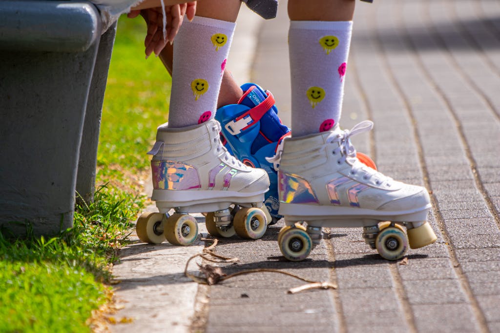 Close-up of colorful roller skates and socks in a sunny park, highlighting playful outdoor fun.